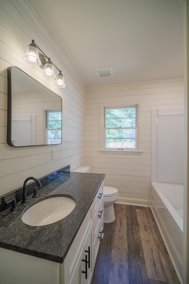 bathroom featuring wood walls, toilet, vanity, and hardwood / wood-style flooring