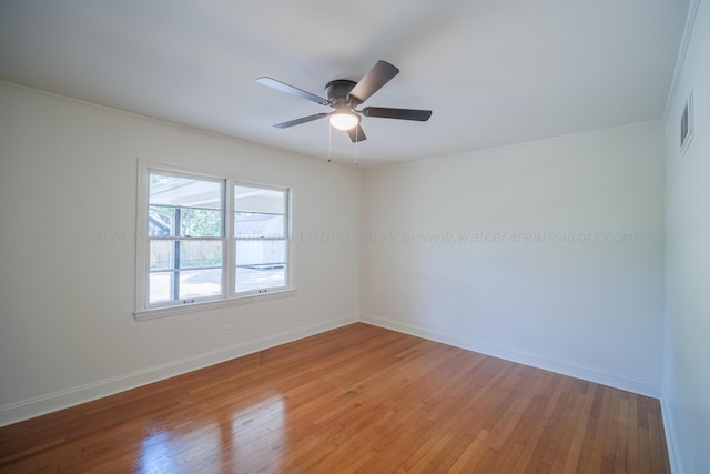 spare room with ceiling fan, crown molding, and light wood-type flooring