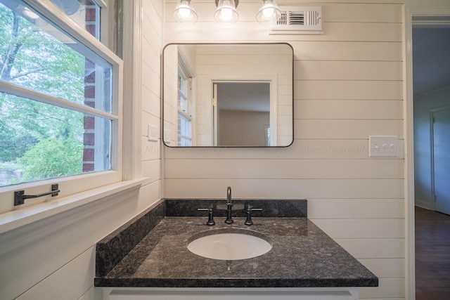 bathroom with vanity, hardwood / wood-style flooring, and wood walls