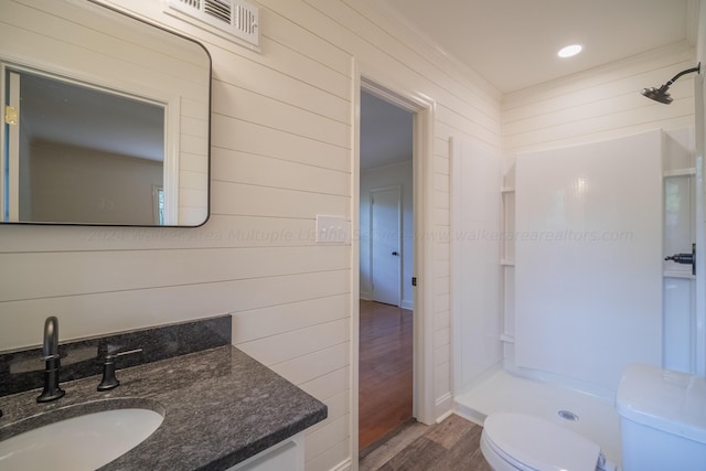 bathroom with vanity, wood walls, toilet, walk in shower, and wood-type flooring