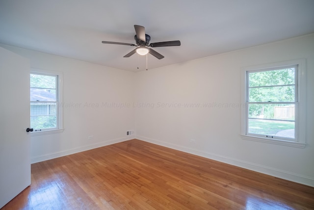 spare room featuring hardwood / wood-style flooring, a wealth of natural light, and ceiling fan