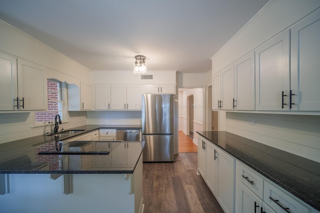 kitchen featuring dark stone counters, stainless steel appliances, dark wood-type flooring, sink, and white cabinetry