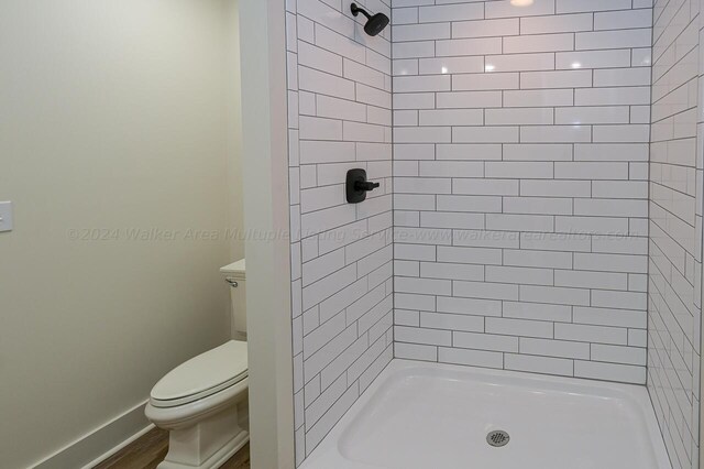 bathroom featuring toilet and a tile shower