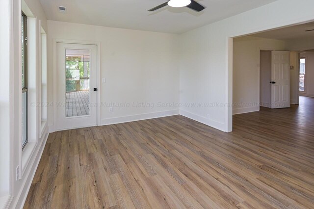 empty room featuring dark wood-type flooring and ceiling fan