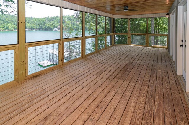 unfurnished sunroom with a water view, ceiling fan, and wood ceiling