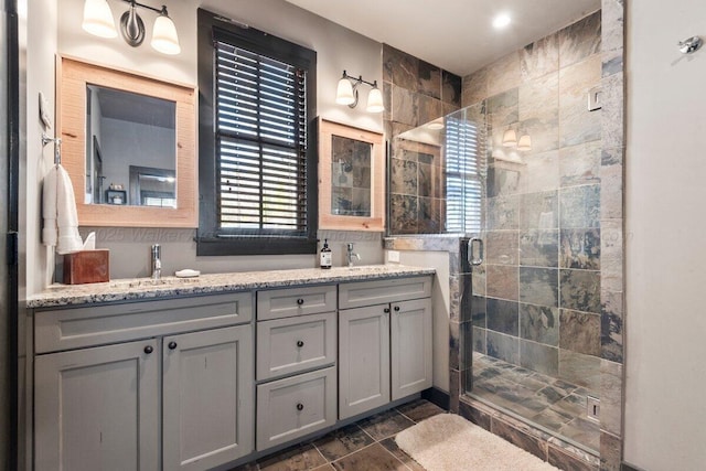 bathroom with a shower with shower door and vanity