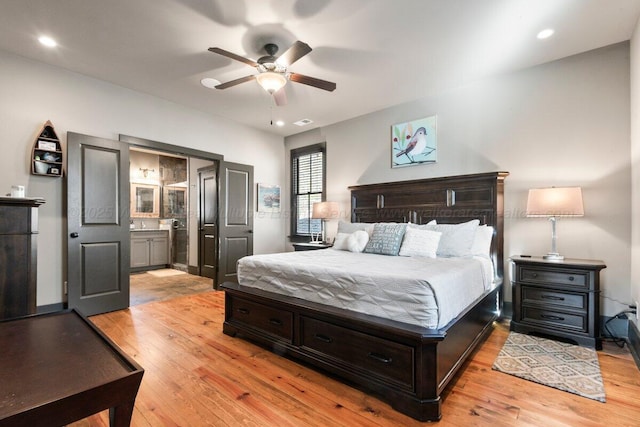 bedroom with ensuite bathroom, ceiling fan, and light hardwood / wood-style floors