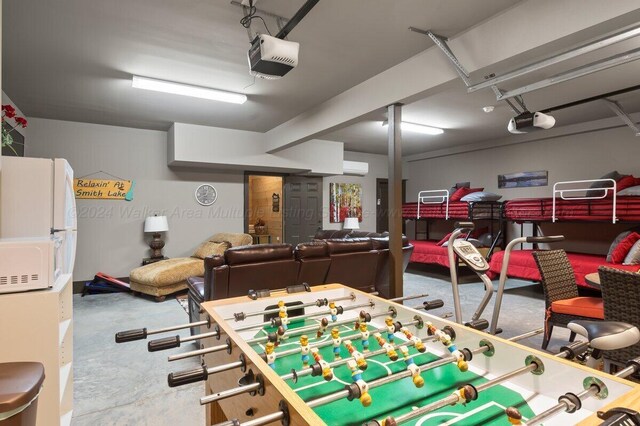 recreation room with concrete floors and a wall mounted air conditioner