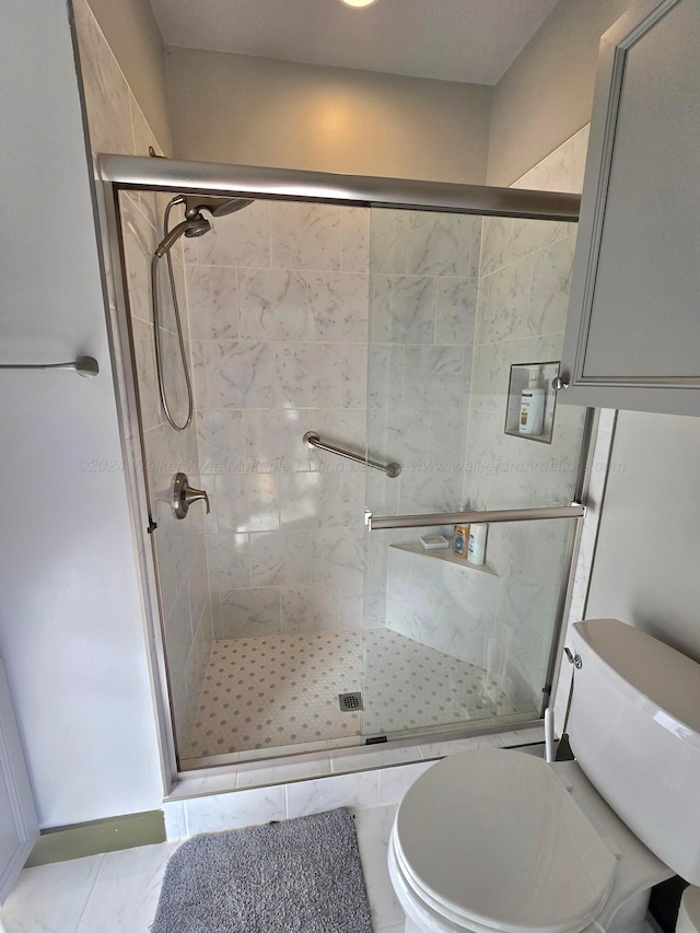 bathroom featuring tile patterned flooring, toilet, and walk in shower