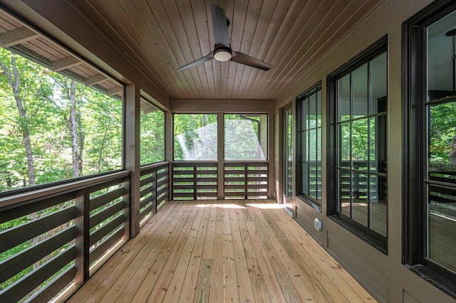 unfurnished sunroom with ceiling fan and wood ceiling