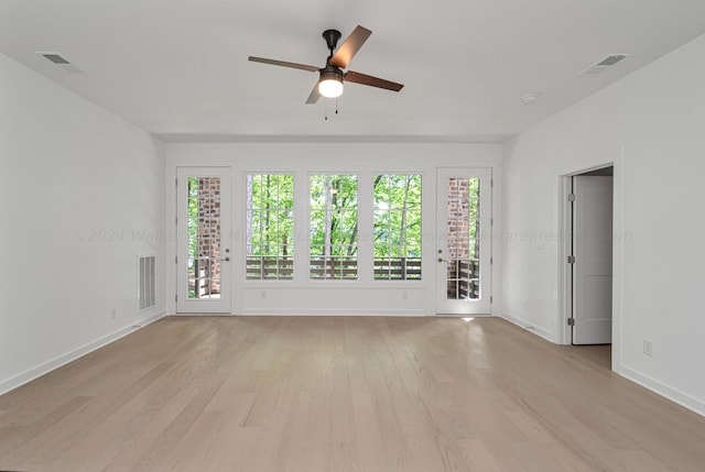 spare room featuring plenty of natural light, ceiling fan, and light wood-type flooring