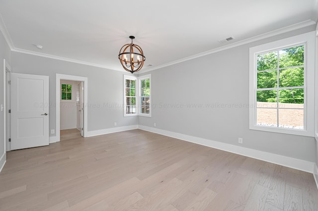 spare room with crown molding, light hardwood / wood-style flooring, and an inviting chandelier