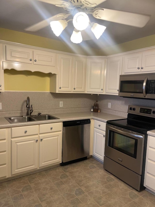 kitchen featuring sink, ceiling fan, appliances with stainless steel finishes, white cabinetry, and backsplash