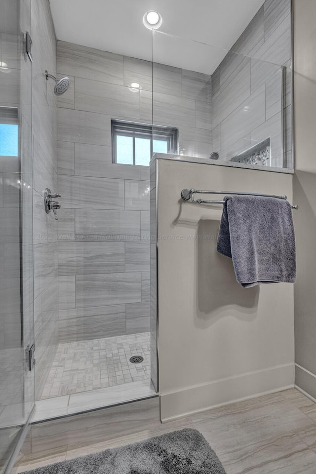 bathroom featuring a shower with shower door