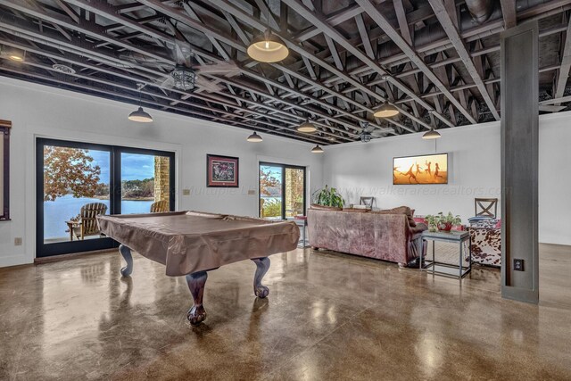 game room with a water view, concrete floors, and billiards