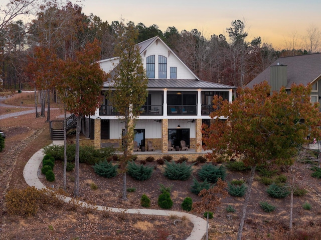 back house at dusk with a balcony