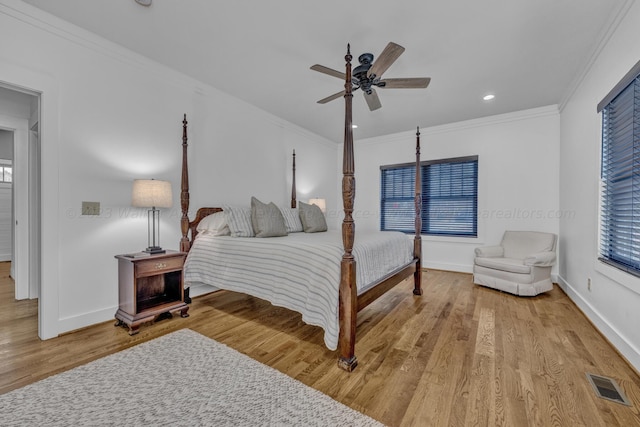 bedroom featuring ceiling fan, crown molding, and light hardwood / wood-style flooring