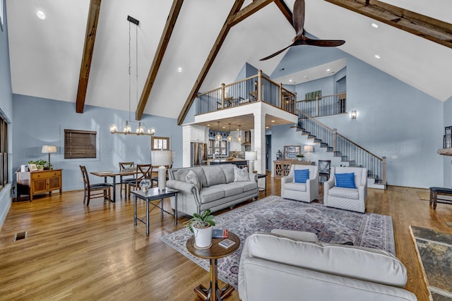 living room featuring beamed ceiling, high vaulted ceiling, and wood-type flooring