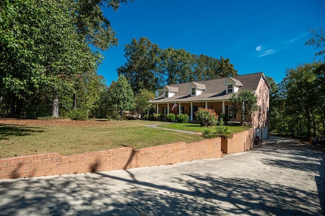 cape cod home featuring a front yard