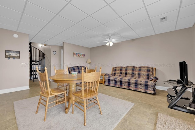 dining room featuring ceiling fan and a drop ceiling