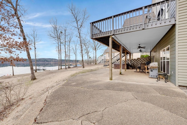 view of patio with a water view and ceiling fan