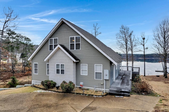 view of front facade with a deck with water view