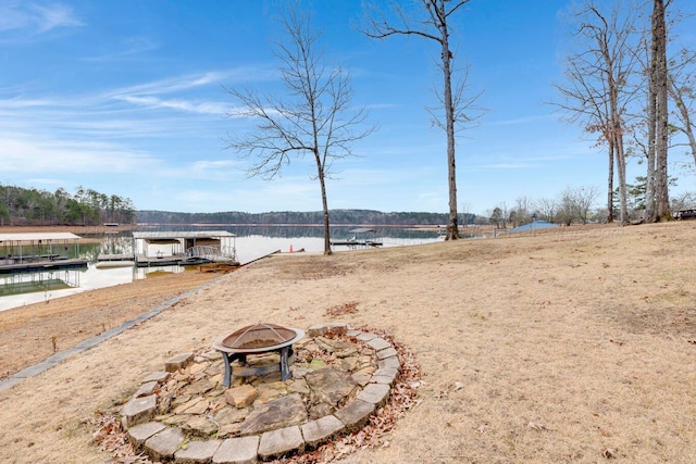 water view featuring an outdoor fire pit and a dock