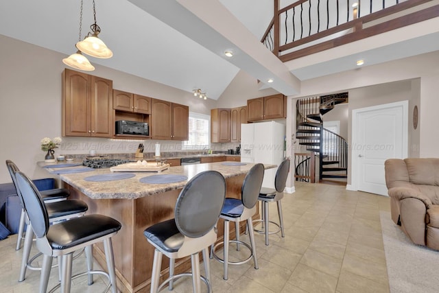 kitchen with a kitchen bar, backsplash, hanging light fixtures, and kitchen peninsula