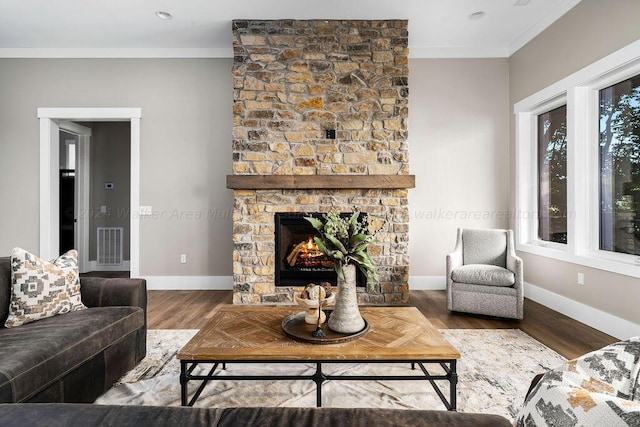 living room featuring a fireplace, wood-type flooring, and ornamental molding