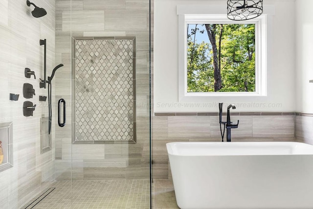 bathroom featuring tile walls and independent shower and bath