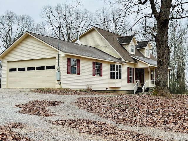 cape cod home featuring covered porch and a garage