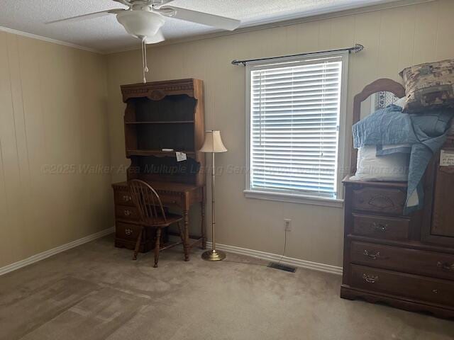 carpeted office featuring baseboards, a ceiling fan, visible vents, and ornamental molding