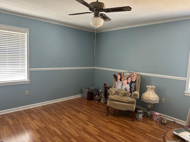 unfurnished room with a textured ceiling, wood finished floors, a ceiling fan, and crown molding