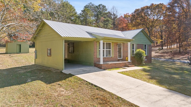 ranch-style home featuring a carport, a storage unit, and a front yard