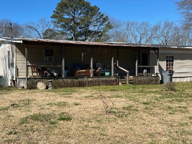 rear view of house featuring a lawn