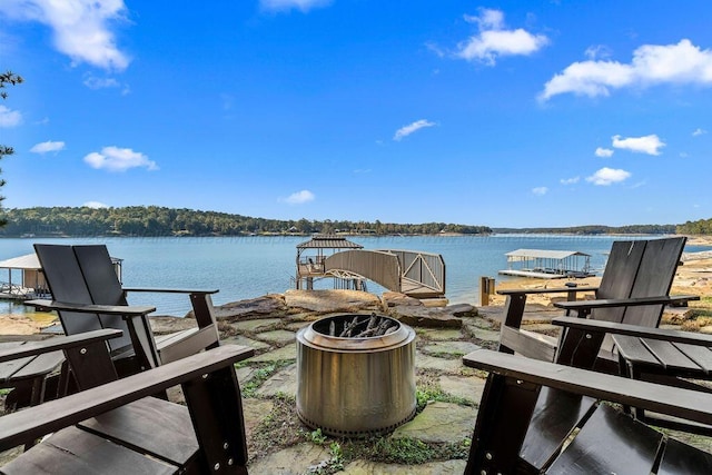 view of dock with a water view and a fire pit