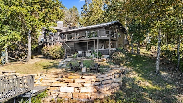 rear view of property featuring a yard and a wooden deck