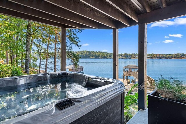 dock area with a water view and a hot tub