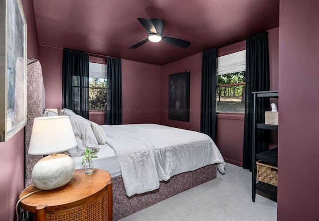 bedroom featuring multiple windows, ceiling fan, and carpet floors