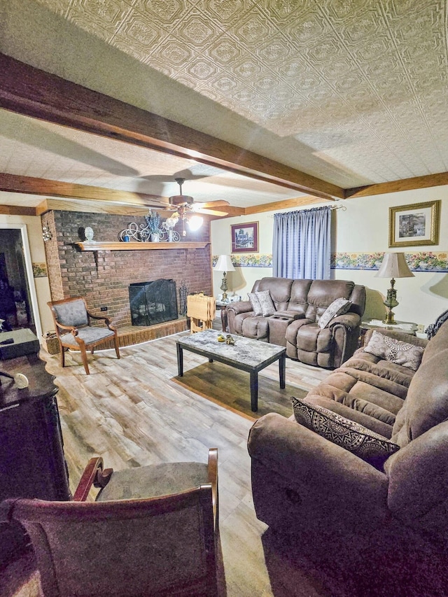 living room with beam ceiling, ceiling fan, and a fireplace