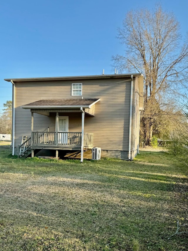 back of house with a deck and a lawn