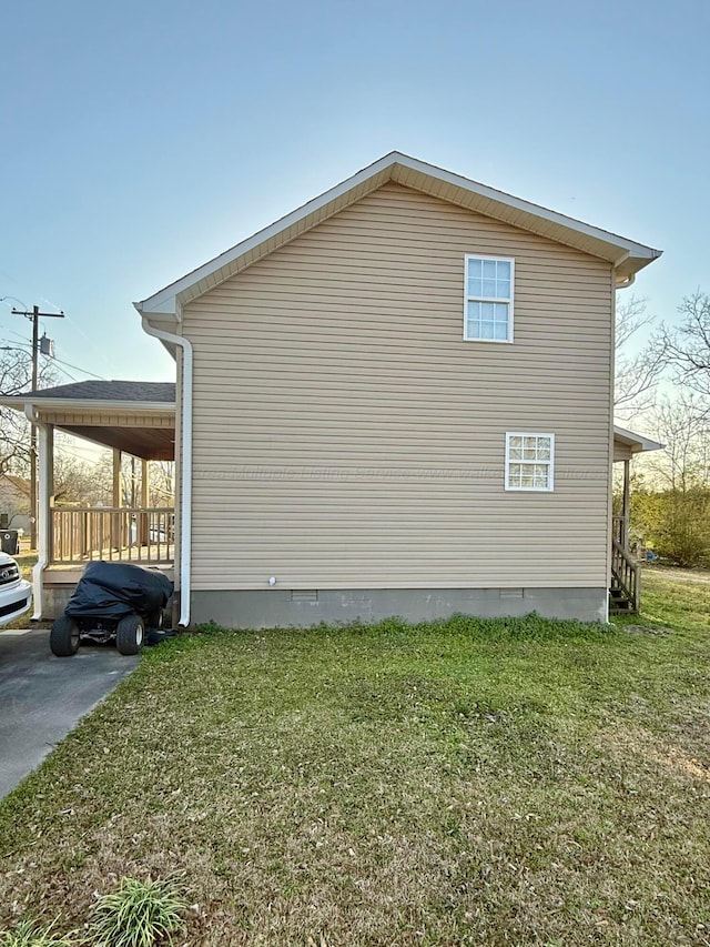 view of home's exterior with an attached carport and a yard