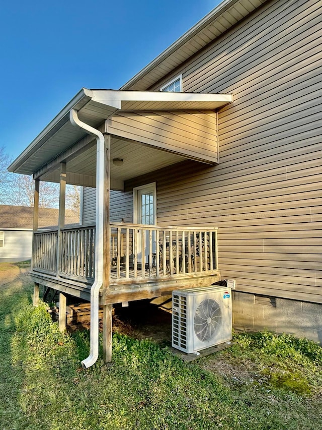 wooden deck featuring ac unit and covered porch