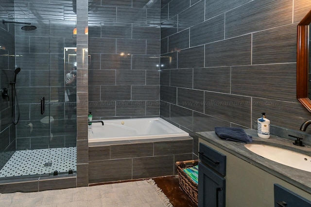 bathroom with independent shower and bath, tile walls, and vanity