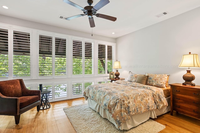 bedroom with ceiling fan, light hardwood / wood-style flooring, and multiple windows