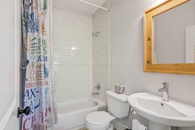 full bathroom with sink, toilet, and shower / tub combo with curtain