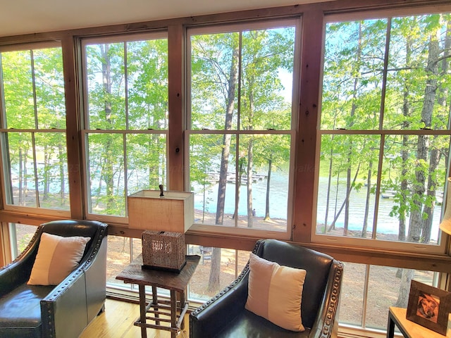 sunroom featuring a water view