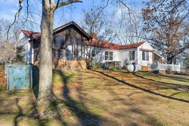 view of front facade with a front yard and a sunroom