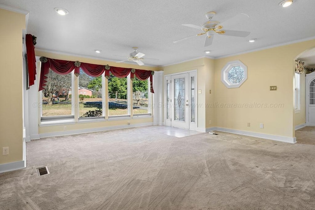 unfurnished living room with ceiling fan, a healthy amount of sunlight, light colored carpet, and crown molding