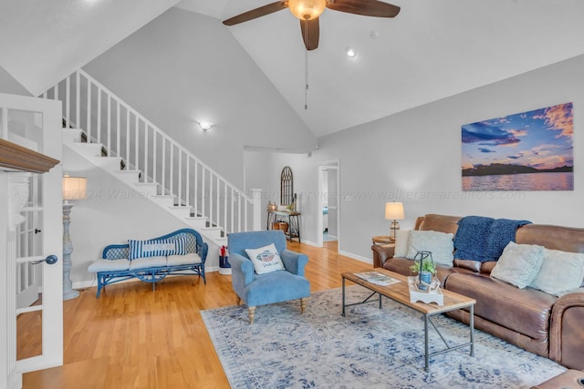 living room featuring hardwood / wood-style floors, ceiling fan, and high vaulted ceiling